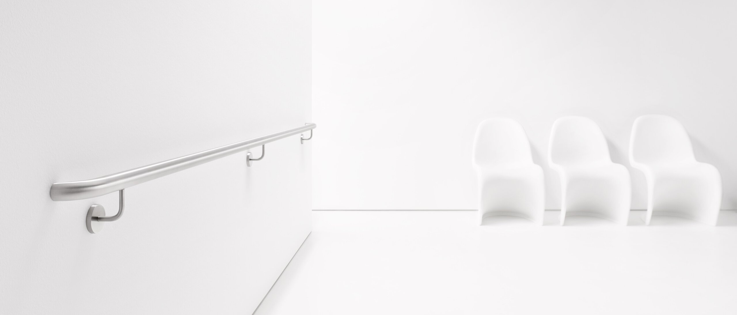 ENTRO stainless steel handrail Stainless steel handrail attached to a white wall with three supports